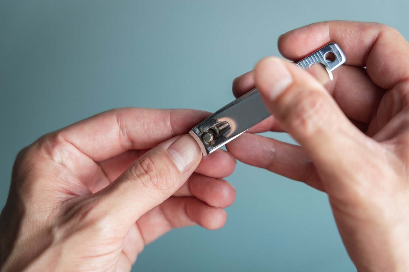 Man Cutting Nails Using Nail Clipper. Manicure